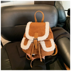 Detailed view of brown suede mini backpack with white faux shearling trim and metal clasp