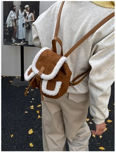 Detailed view of mini brown backpack with white faux shearling trim and drawstring