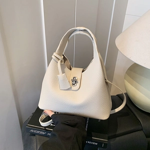Beige lychee pattern leather bucket bag with silver twist lock and shoulder strap