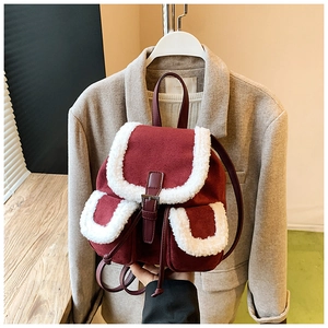 Detail of burgundy suede backpack with fuzzy faux shearling trim and buckle closure