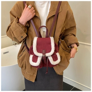 Macro detail of burgundy faux shearling backpack with vintage buckle and soft plush trim