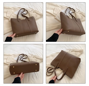 Detail view of brown tote bag showing protective gold feet and premium lychee grain texture