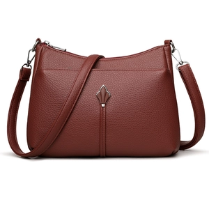 Minimalist deep red crossbody bag with litchi grain texture and metal leaf charm