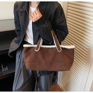 Detail of suede tote bag with white faux fur trim and adjustable shoulder strap