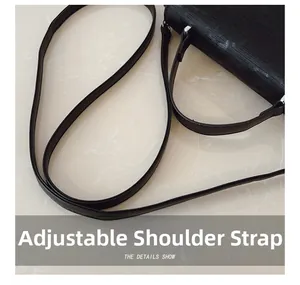 Detail of adjustable black leather strap with silver metal hardware on a modern handbag