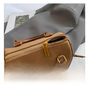 Detailaufnahme der braunen Kissentasche aus Leder mit goldenen Metallteilen und Reißverschluss