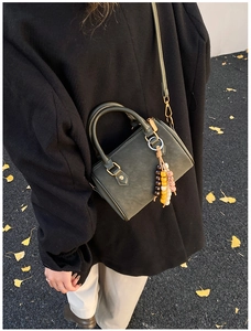 Dunkelgrüne matte Boston-Tasche mit bunten Perlen an einem Modell im herbstlichen Stil