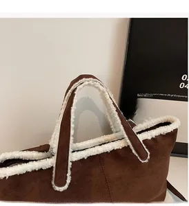 Detail of suede tote bag with faux shearling trim and durable reinforced top handles