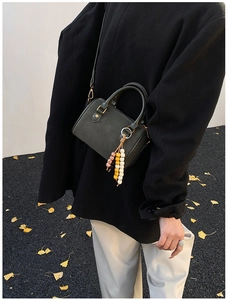 Detailansicht der dunkelgraugrünen Boston-Tasche mit Perlenanhänger und Schultergurt