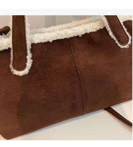 Detail view of brown suede tote bag featuring plush white faux fur trim and fine stitching