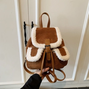 Brown suede backpack with white faux fur trim and leather straps shown against a white door