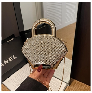Close-up of luxury fan-shaped champagne gold evening bag with rhinestones and chain strap