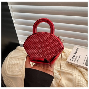 Detail of red rhinestone evening bag with acrylic finish and golden chain strap