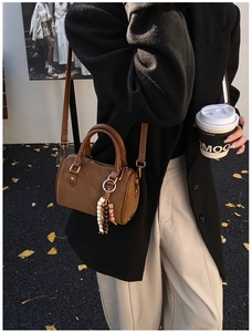 Braune Boston-Tasche aus Wildleder mit Perlenanhänger zu schwarzem Wollmantel