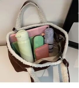 Macro view of suede tote bag with faux shearling trim showing large interior capacity