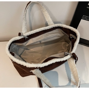 Interior detail of suede tote bag with faux shearling trim and zipper pocket