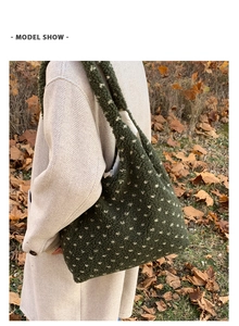 Detail of dark green sherpa shoulder bag with white patterns on a model in autumn park