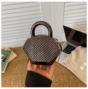 Detail of dark brown acrylic evening bag with beaded texture and round handle