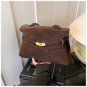Gros plan du sac cabas rétro en cuir marron avec fermoir tournant doré et bandoulière