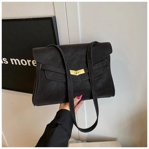 Détail du sac cabas vintage noir montrant le fermoir pivotant en métal doré et la sangle
