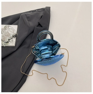 Detail of blue metallic shell clutch bag with gold chain strap and open interior