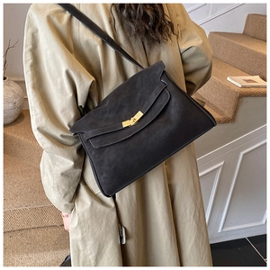 Détail du cabas vintage en cuir souple noir avec fermoir rotatif en métal doré rétro