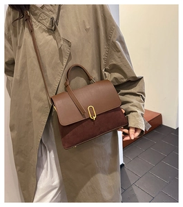 Detailed close-up of retro color-block handbag showing brown leather and burgundy suede