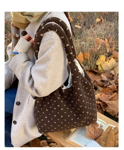 Close-up of brown plush tote bag with white polka dots in a cozy autumn setting