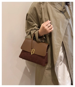Detail of a retro patchwork handbag styled with an olive trench coat for work