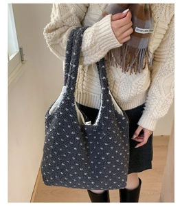 Close-up of grey plush tote bag with white polka dots featuring soft wool-like texture