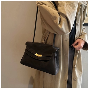 Détail du sac vintage en cuir souple avec fermoir rotatif doré et bandoulière