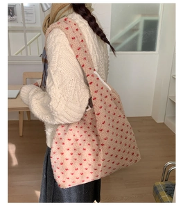 Detail of soft cream plush tote bag with red heart pattern for winter fashion
