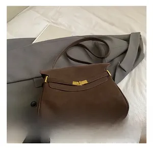 Détail de la sacoche rétro en cuir marron foncé avec fermoir rotatif en métal doré