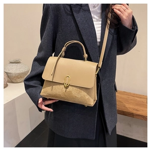 Detail view of khaki patchwork shoulder bag with gold oval lock and matte texture finish