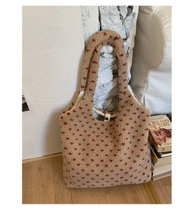 Detail of plush lamb wool tote bag with red heart embroidery and wide shoulder strap