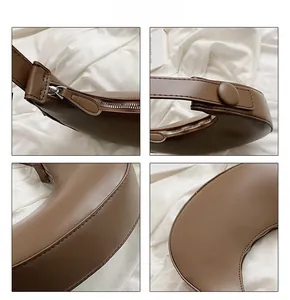 Detailed close-up of brown crescent bag showing smooth zipper and stitching quality