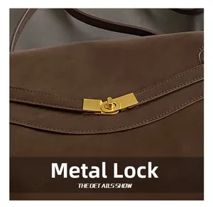 Gros plan du fermoir rotatif doré sur le sac fourre-tout vintage en cuir marron