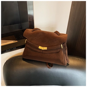 Détail du sac cabas en daim marron avec fermoir tournant doré et lanières en cuir rétro