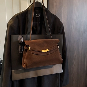 Détail du sac à bandoulière en daim marron vintage avec boucle en métal doré minimaliste