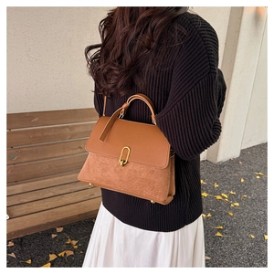 Detail view of caramel patchwork shoulder bag with suede texture and gold oval lock