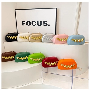 Detailed array of colorful acrylic oval evening bags with golden wave metallic trim