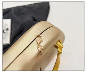Macro detail of high-quality gold hardware and polished metal chain on evening clutch