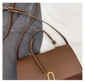 Detail of vintage patchwork crossbody bag with brown leather and gold U-shaped hardware