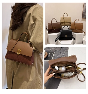 Detailed view of color-block crossbody bag featuring metal buckle and dual compartments