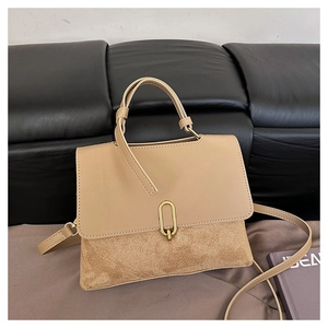 Detailed view of khaki patchwork handbag with gold metal clasp and suede texture