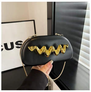 Detail of semi-oval black leather clutch with golden wave metal trim and snake chain strap