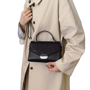 Versatile black handbag with textured flap and silver metal buckle for women's daily commute