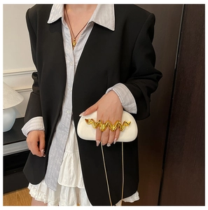 White semi-circle cloud clutch bag with gold wavy metal handle shown on a model