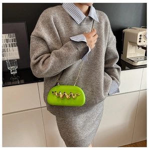 Neon green asymmetric crossbody bag with wave metal decor shown on a model