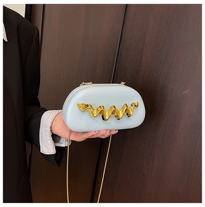 Detail of light blue semi-circular evening clutch with golden wave metal trim and fine texture